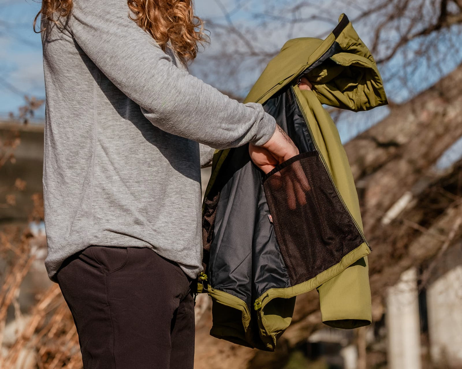 Man wearing a Traveler Tee starting to pack his Daily Driver Puffy Jacket.